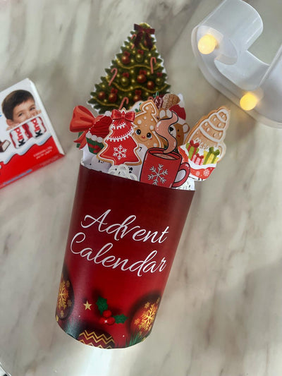 Red Advent calendar with Christmas-themed decorations on a marble surface.